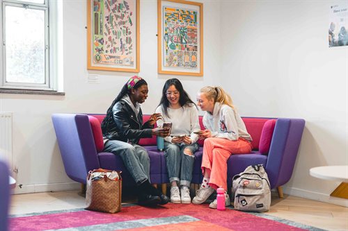Three students sitting in Arts building reception